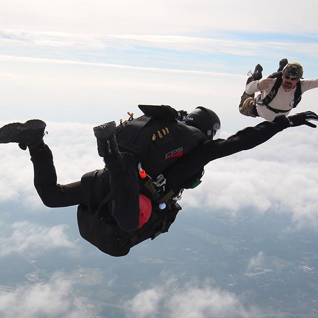 Skydiver in freefall with parachute jump instructor during a skill development training course