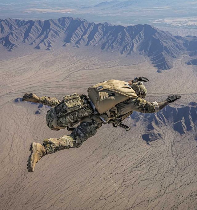 Jumper utilizing modern military equipment and a Military Javelin container in freefall above desert mountains
