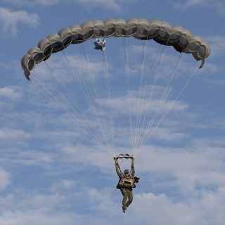 Jumper with K9 flying beneath the Military Phoenix parachute